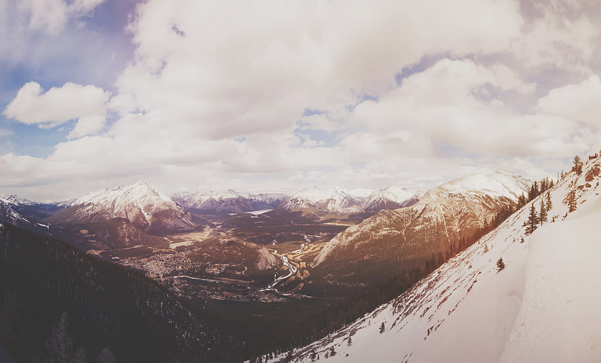Snowy Mountain Valley Landscape with Cloudy Sky