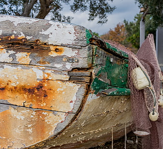 Close-up of weathered wooden fishing boat with peeling paint