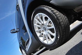 Close-up of blue car wheel and tire on asphalt