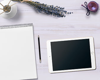 Flat lay workspace with tablet, notebook, and lavender