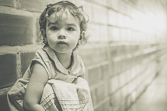 Vintage Portrait of a Young Girl Leaning Against a Brick Wall