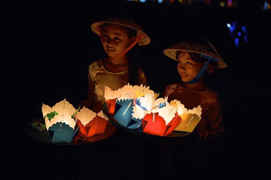 Two Vietnamese Girls Holding Glowing Lotus Lanterns at Night