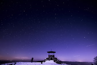 Starry Night Sky Over Snowy Mountain Shelter