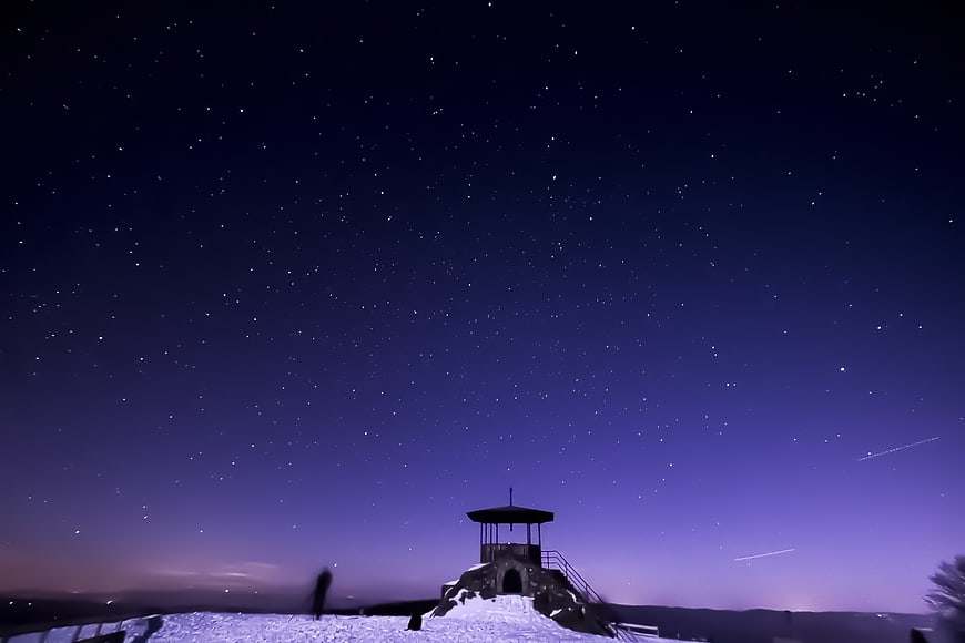 Starry Night Sky Over Snowy Mountain Shelter