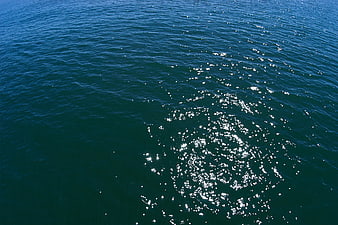 Sparkling Blue Ocean Water Surface with Sunlight Reflections