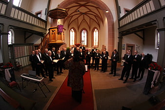 Male choir singing in a historic church interior with gothic architecture