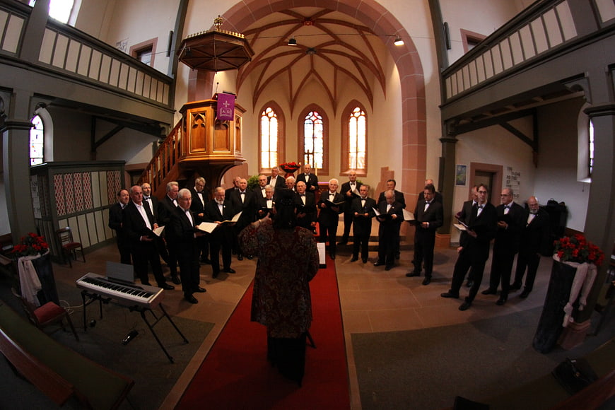 Male choir singing in a historic church interior with gothic architecture