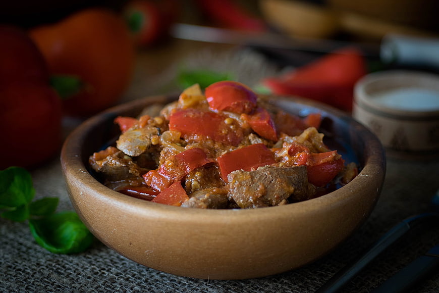 Rustic Chicken Liver Stew with Peppers in Wooden Bowl