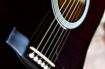 Close-up of Black Acoustic Guitar Strings and Bridge