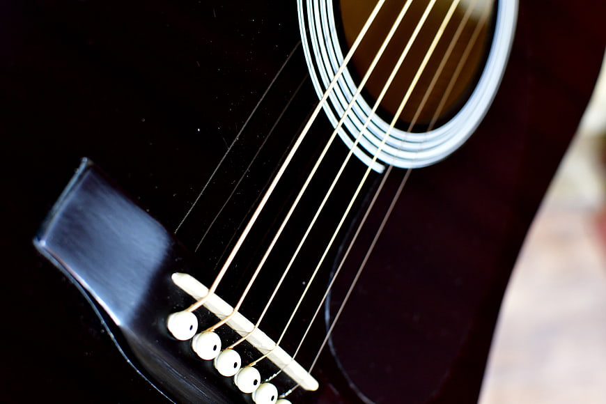 Close-up of Black Acoustic Guitar Strings and Bridge