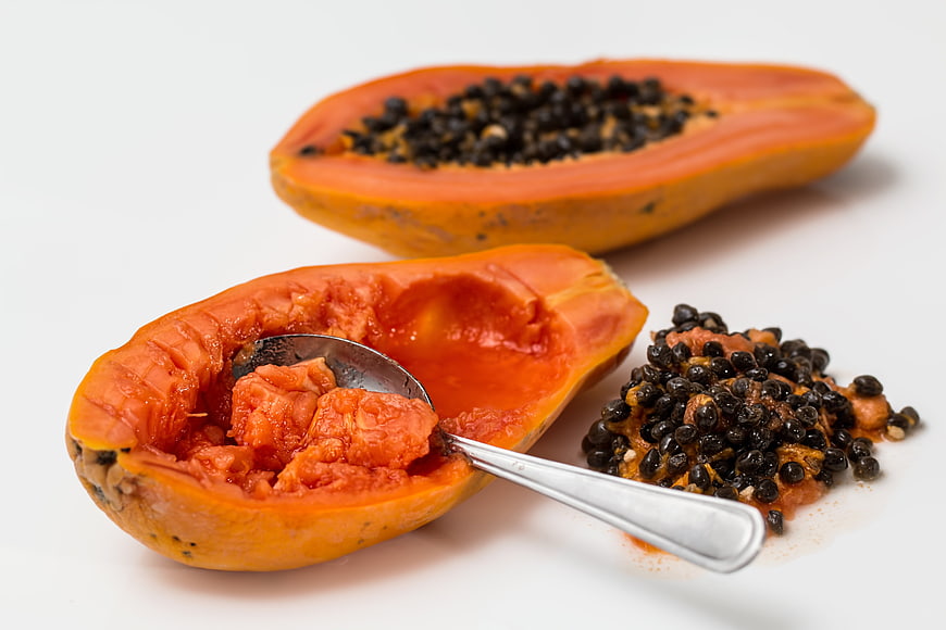Fresh Ripe Papaya Halves with Seeds and Spoon on White