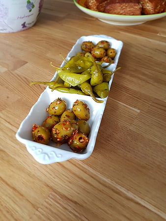Marinated olives and peppers on a wooden table