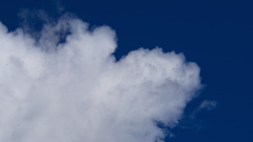 Fluffy White Clouds Against Deep Blue Sky