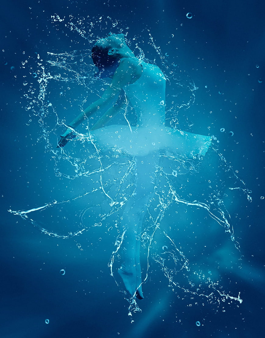 Underwater ballerina in white tutu with water splashes