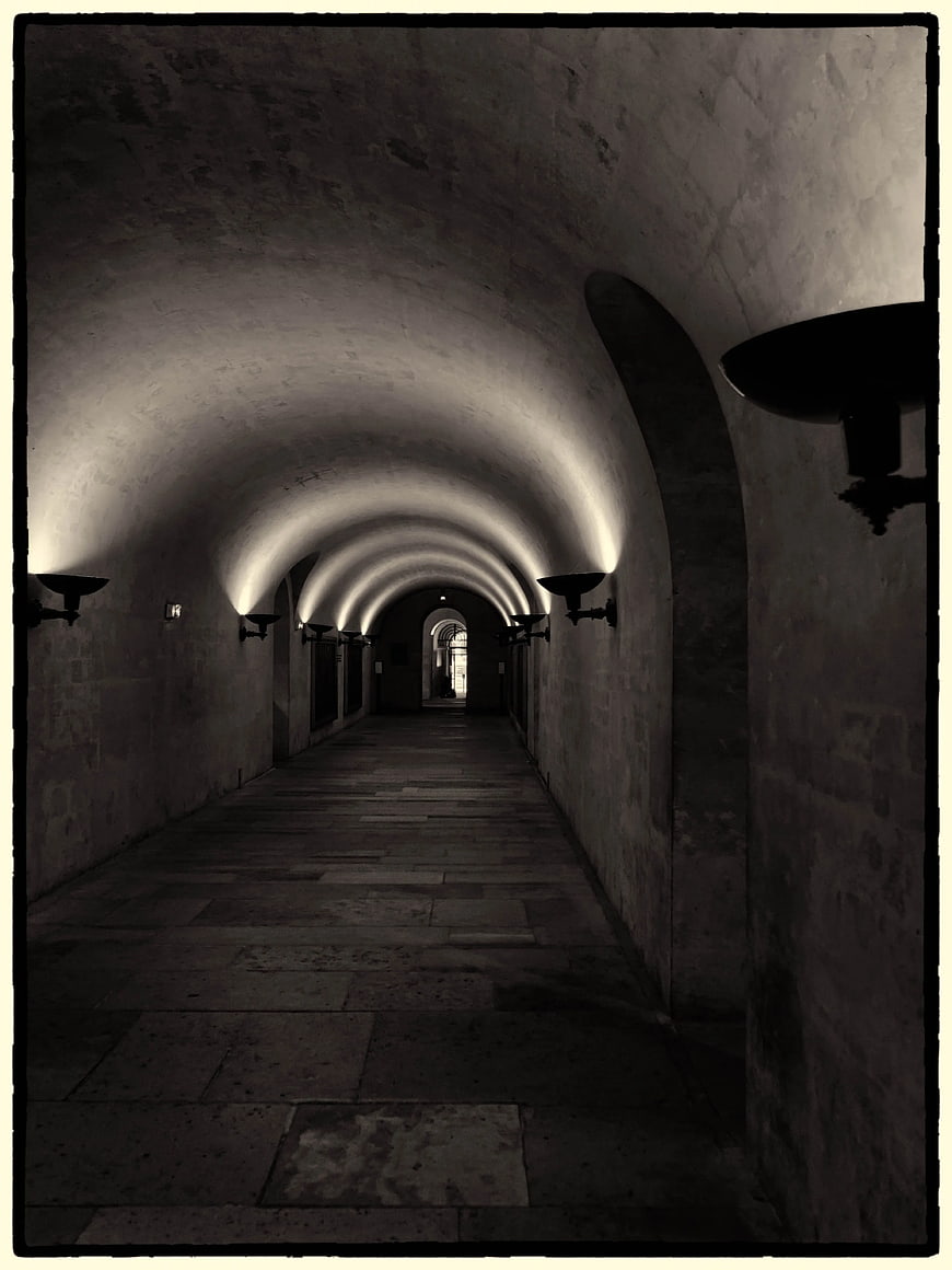 Dark Arched Stone Corridor with Dramatic Lighting