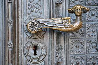 Ornate Brass Angel Doorknob on Antique Metal Door