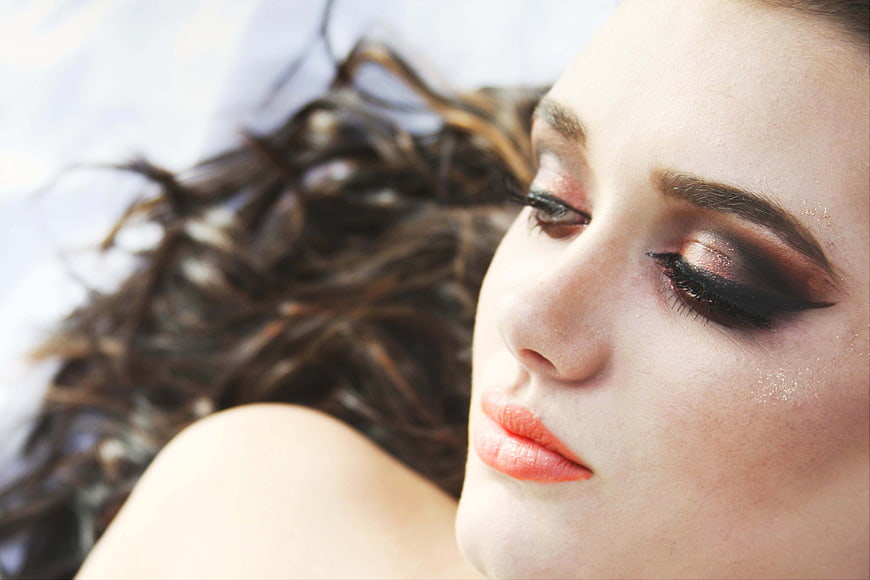 Close-up portrait of woman with dramatic glitter makeup