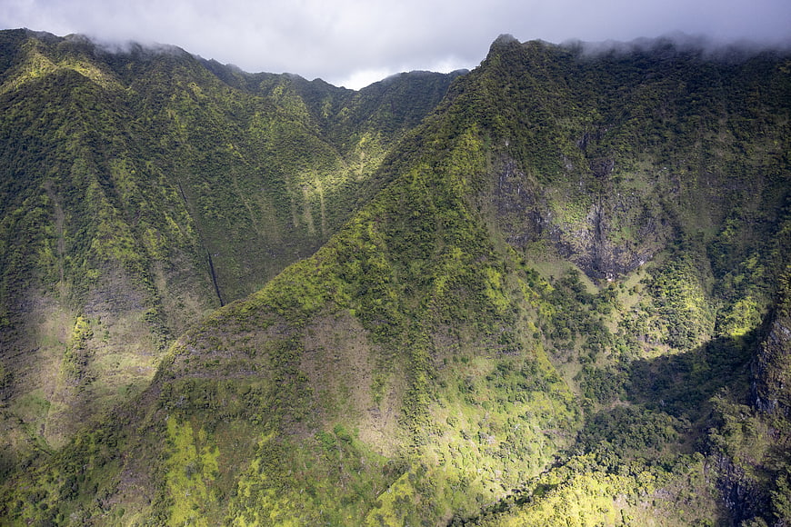 Lush green mountain ridges with clouds and mist