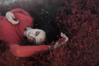 Woman in Red Sweater Lying in Autumn Foliage
