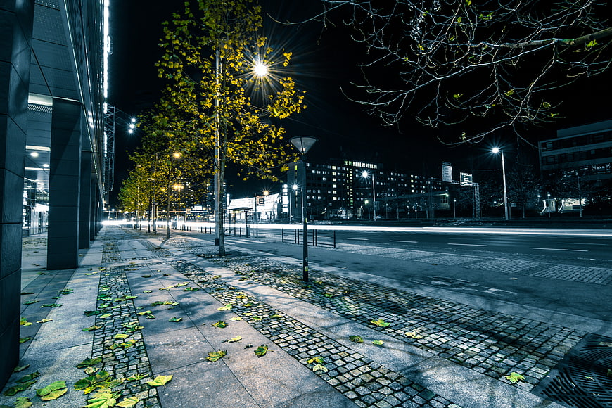 Empty Urban Street at Night with Cobblestone Sidewalk