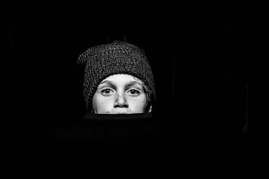 Dramatic black and white portrait of a boy in a beanie