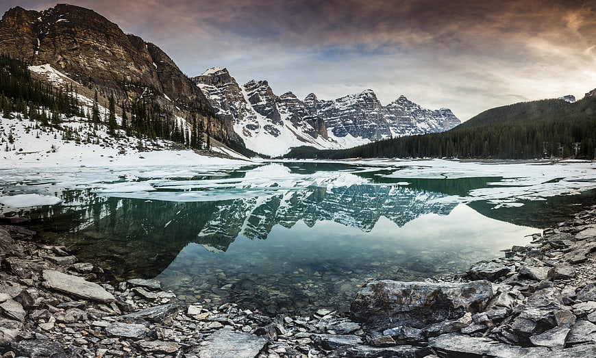 Snowy Mountain Peaks Reflected in Icy Lake at Dusk