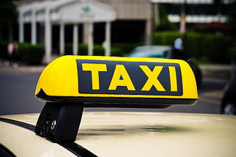 Close-up of a yellow taxi sign on a car roof