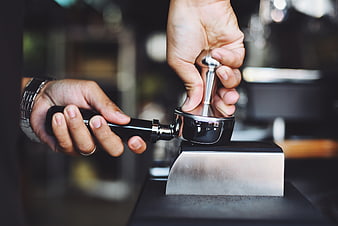 Barista Tamping Espresso Coffee Grounds in Portafilter