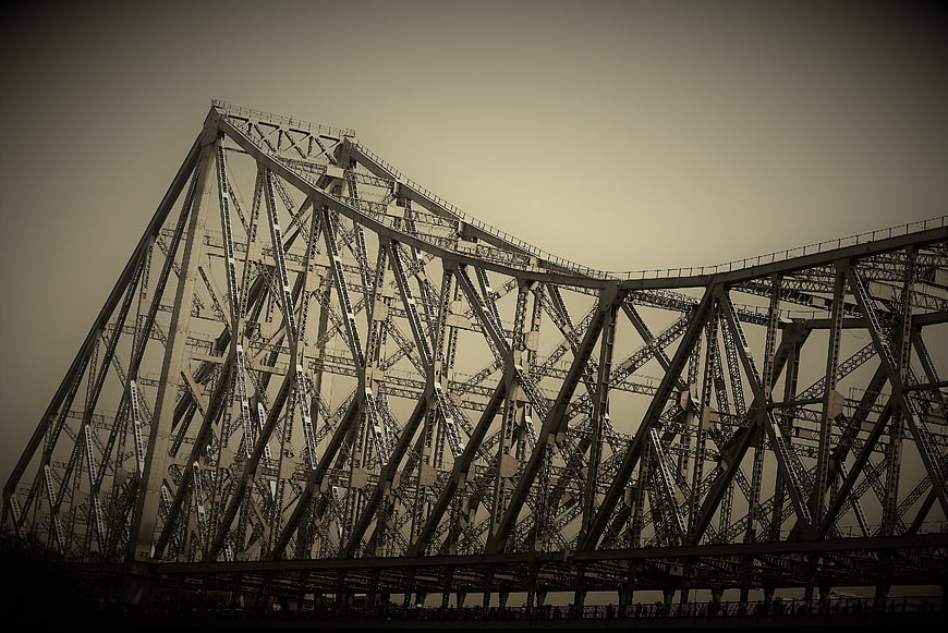 Low angle view of steel truss bridge structure against sky