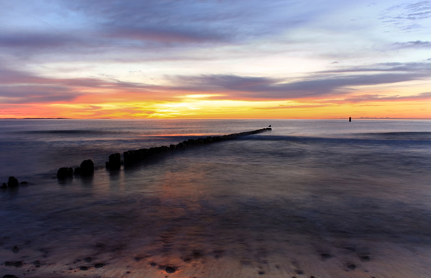 Long Exposure Sunset Over Ocean with Wooden Groyne