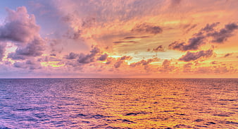 Vibrant Sunset Over Ocean with Purple and Orange Clouds