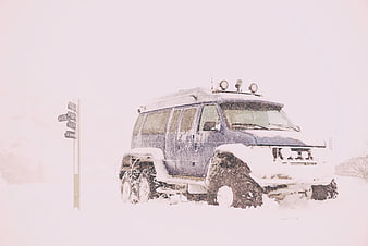 Blue 6x6 Expedition Vehicle in Heavy Snowstorm