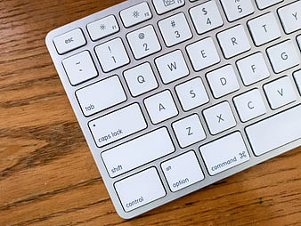 Close-up of white computer keyboard on wooden desk