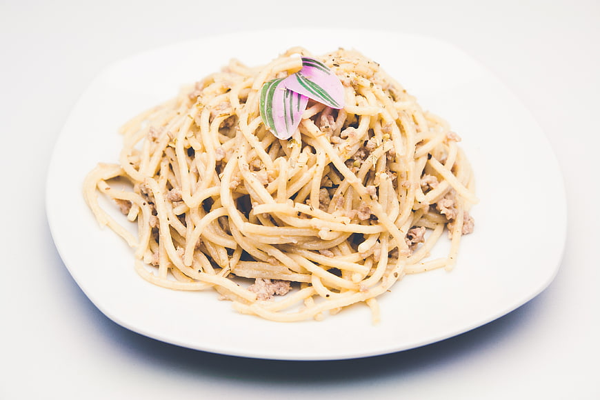 Creamy Spaghetti Carbonara on White Plate with Herb Garnish