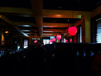 Dimly lit restaurant interior with pink pendant lights
