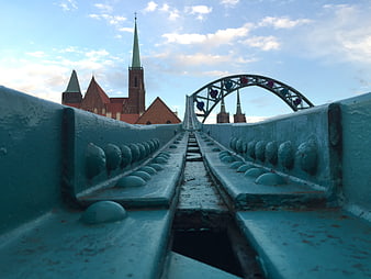 Low angle view of blue bridge structure with city skyline