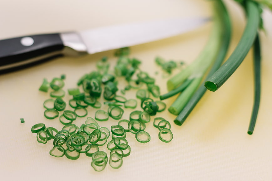 Freshly Chopped Green Onions on Cutting Board with Knife