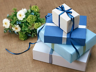 Stack of Blue and White Gift Boxes with Flowers on Burlap