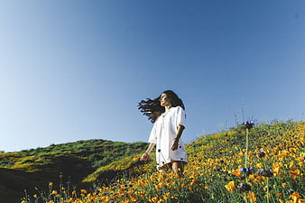 Woman in White Dress Walking Through Yellow Poppy Field