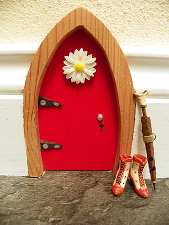 Miniature red fairy door with daisy and boots