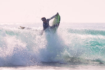 Surfer performing aerial maneuver on ocean wave