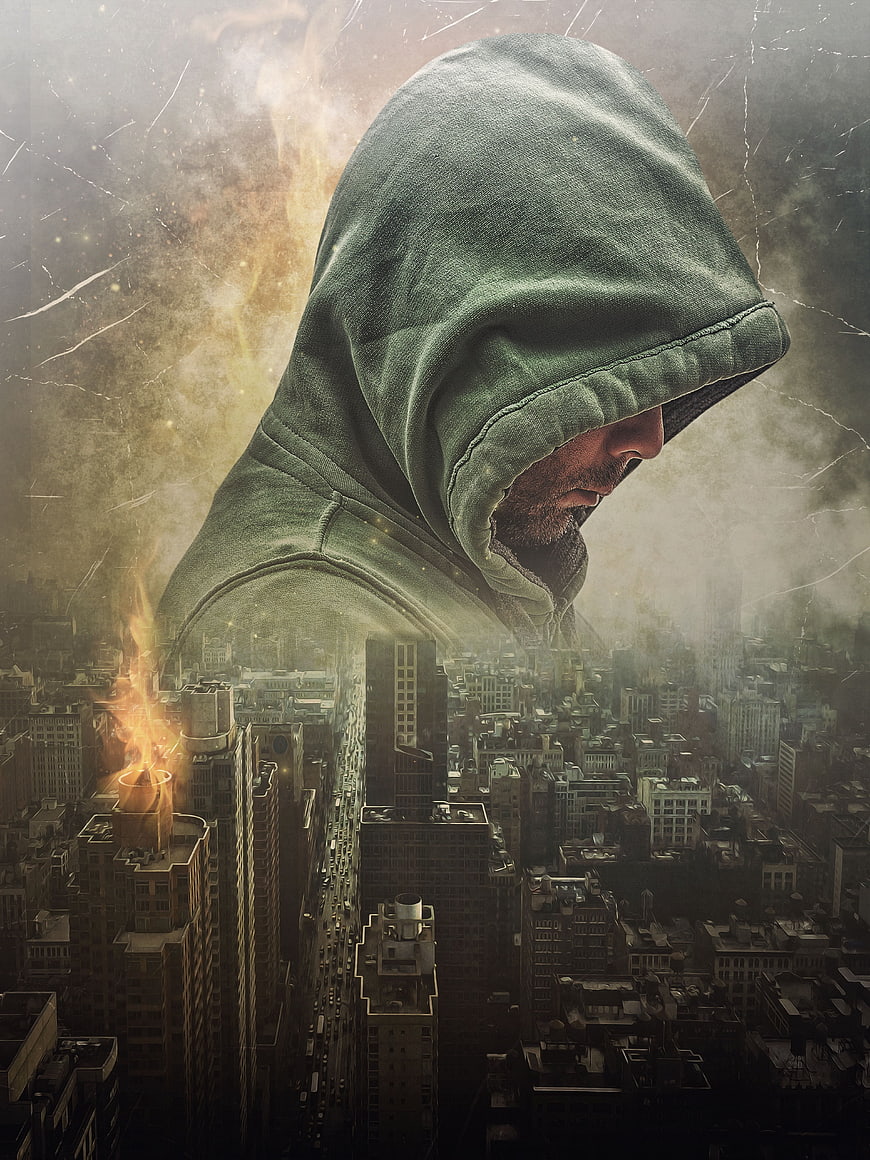 Hooded Man Silhouette Over Dark City Skyline With Fire And Smoke