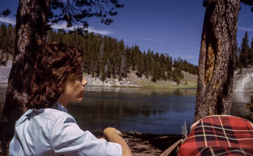 Vintage woman sitting by a lake in a forest