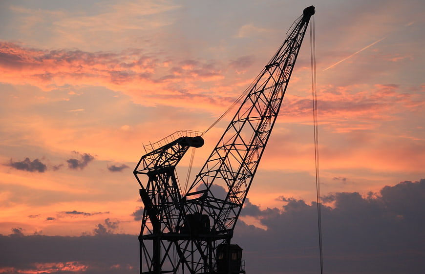 Silhouette of Harbor Crane Against Vibrant Sunset Sky
