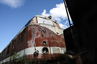 Rusty vintage locomotive against blue sky