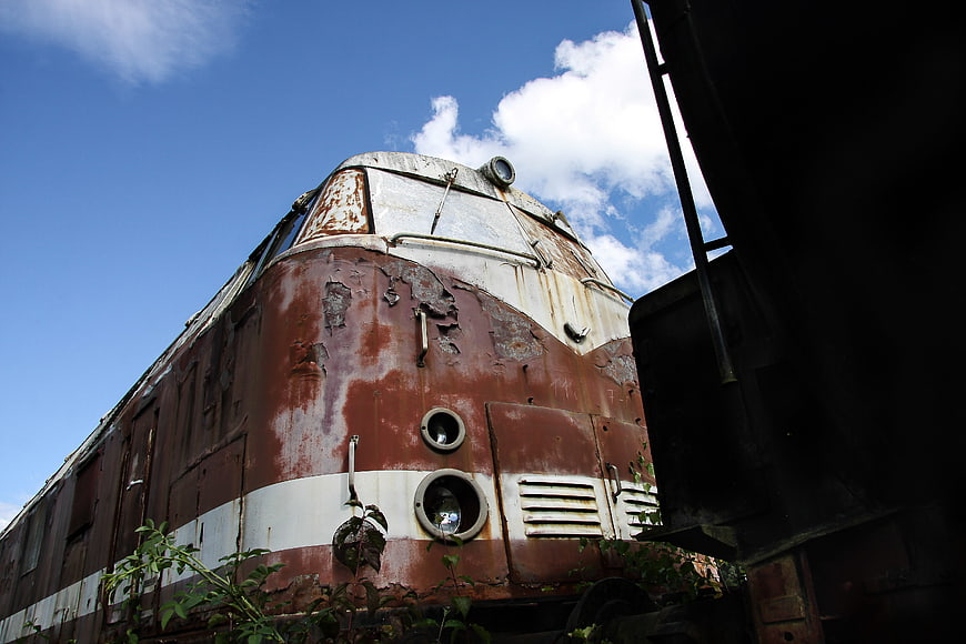 Rusty vintage locomotive against blue sky