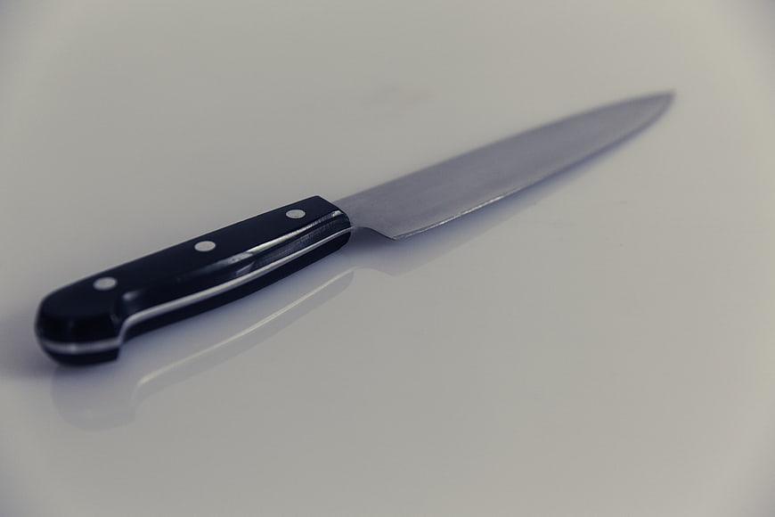 Sharp Chef Knife on White Surface with Reflection