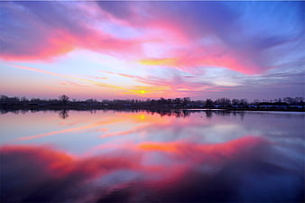 Vibrant Pink and Purple Sunset Reflection on Calm Lake