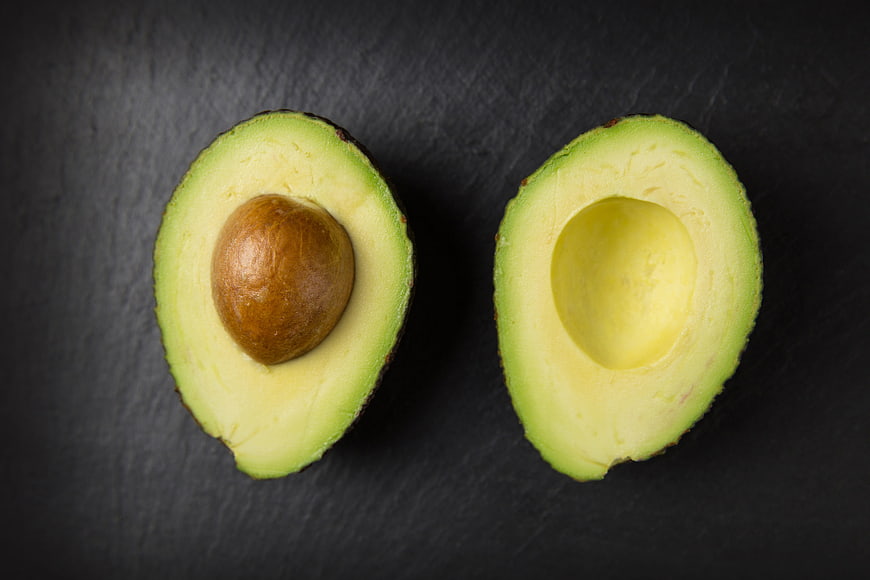 Fresh Halved Avocado on Dark Slate Background