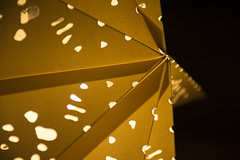 Close-up of yellow paper lantern with cut-out patterns